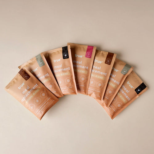 True meal replacement sample bundle — seven beige resealable pouches of "Natural Blend" meal replacement powder in assorted flavors, arranged fan-style on a neutral background (Australian online health-food product).
