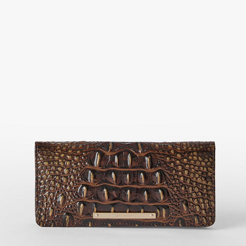 A brown crocodile-embossed clutch wallet with a gold-tone metal bar clasp, shown against a plain light gray background. Ady wallet front view.