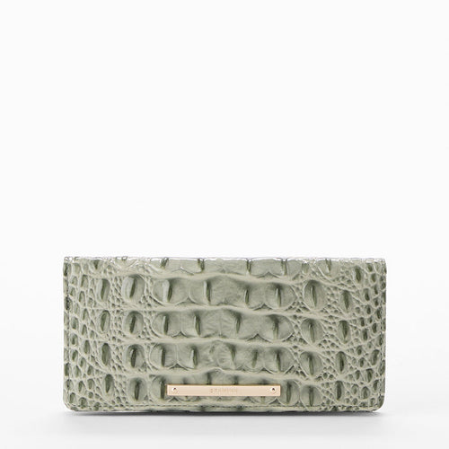 A rectangular clutch bag with a crocodile-embossed texture in sage green, featuring a small gold-tone metal bar at the bottom center.