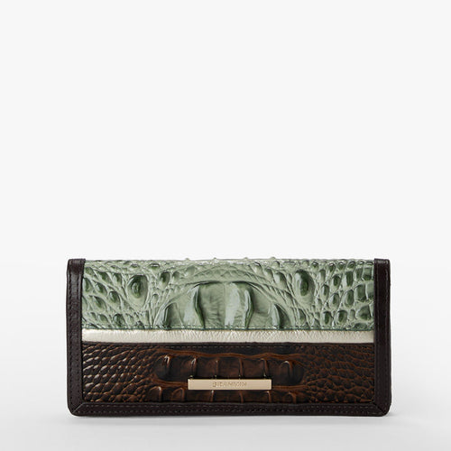 A rectangular wallet featuring a light green alligator-textured flap and a dark brown crocodile-textured lower section, separated by a thin white stripe, with a small gold-tone metal Brahmin bar on a white background.