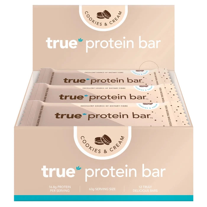 True Protein Bar cookies & cream display box with 12 individually wrapped 63g bars, beige retail box showing "true protein bar", "16.8g protein per serving" — pack of 12 high-protein snack bars, cookies & cream flavor.