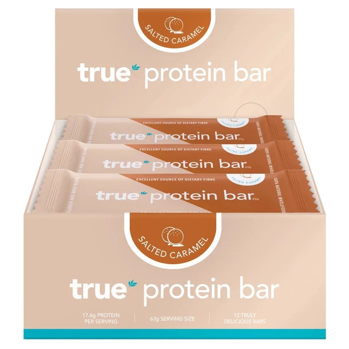 Box of 12 True Protein Bar salted caramel flavor, beige retail display showing individually wrapped 63g bars, 17.6g protein per serving — protein snack bars for fitness and recovery.