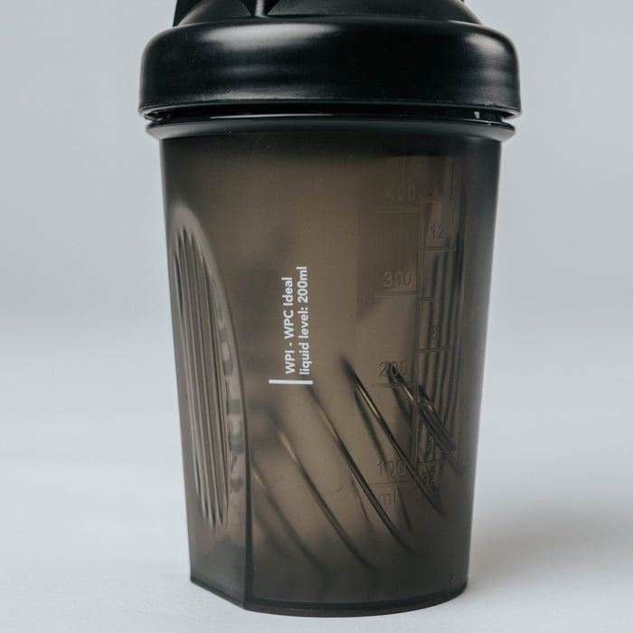 Black translucent small protein shaker bottle with black screw lid, 200–300 ml measurement markings and internal mixing grid — fitness supplement shaker cup product photo
