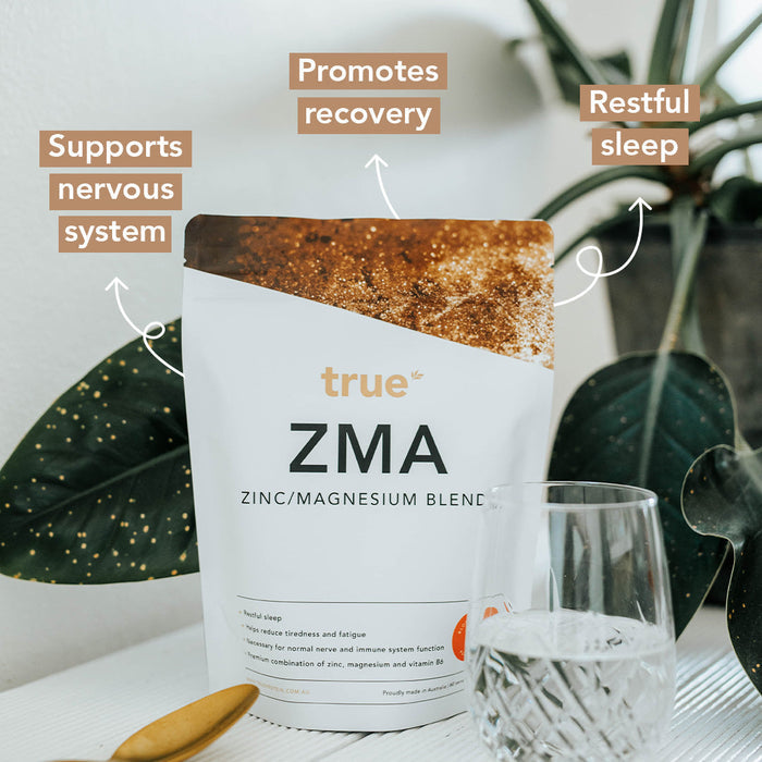 True ZMA zinc & magnesium blend supplement pouch by True on white table with gold spoon, glass of water and plant — promotes recovery, restful sleep and supports nervous system, proudly made in Australia