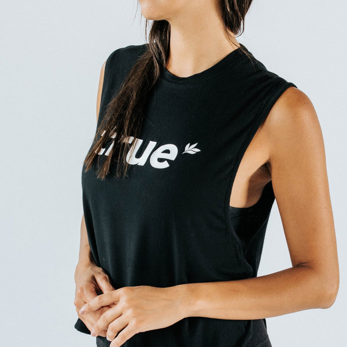 Women's black cropped muscle tank top with white "True" logo, sleeveless athletic casual top on model — studio close-up for women's fitness apparel.